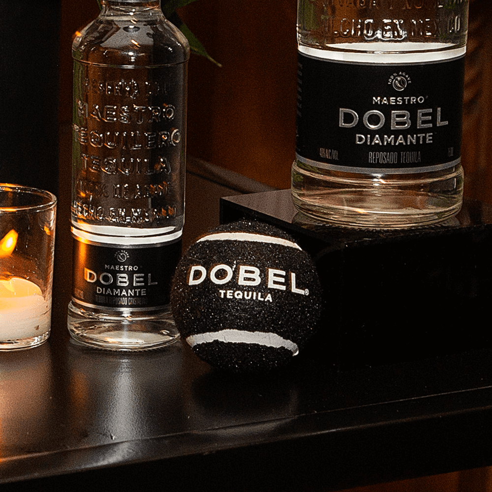 Black Dobel tennis ball with bottles and candles.