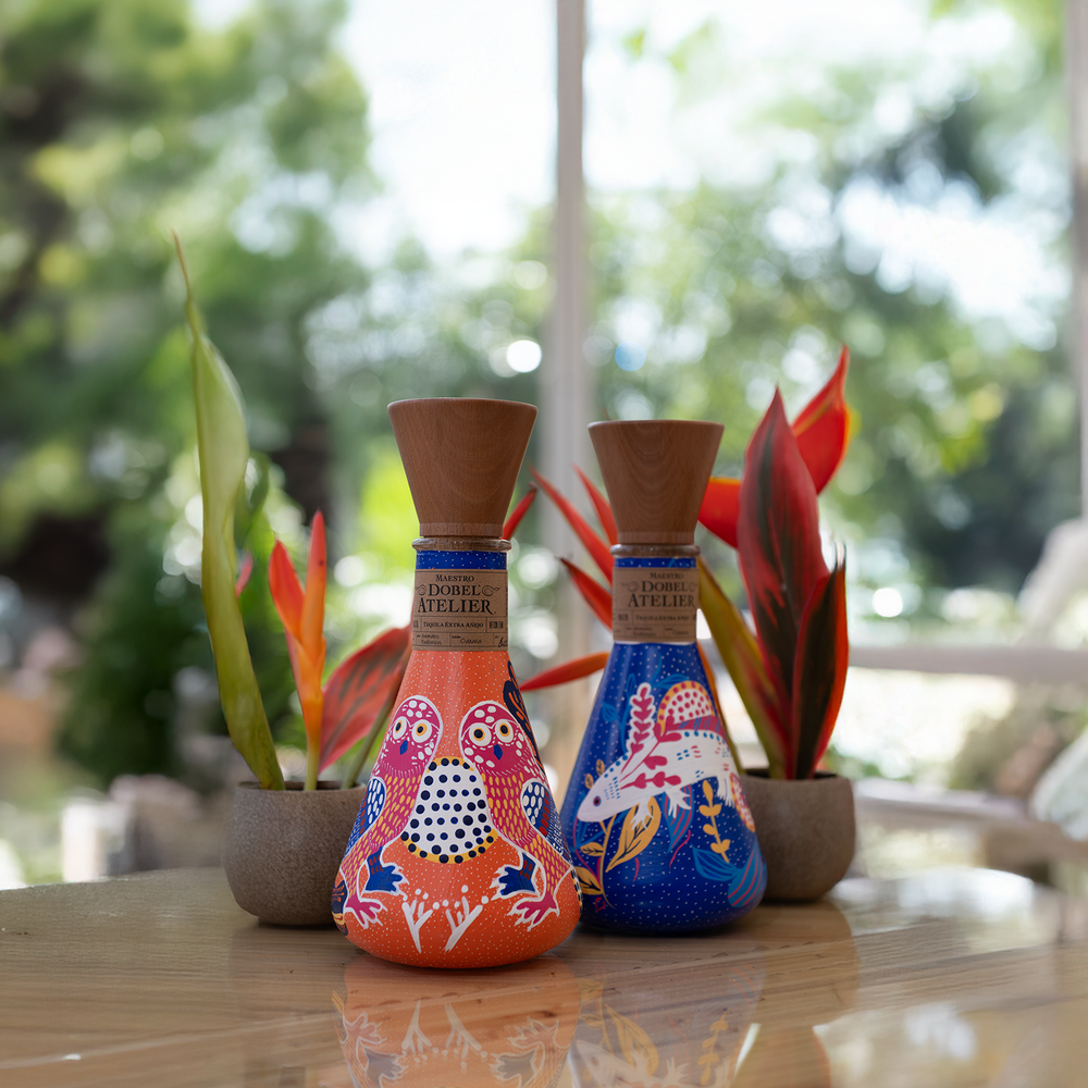 Dobel Atelier: Animales Endémicos Edition pink and blue bottle on table.