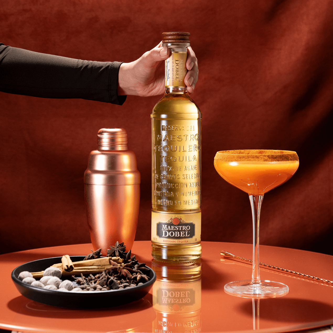 Dobel Reposado bottle with cocktail shaker and orange cocktail