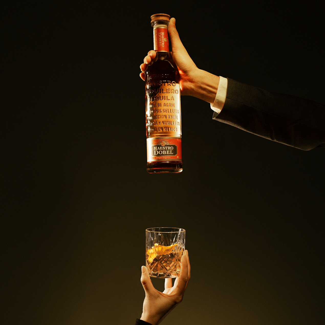 Dobel Añejo in hand with served drink.