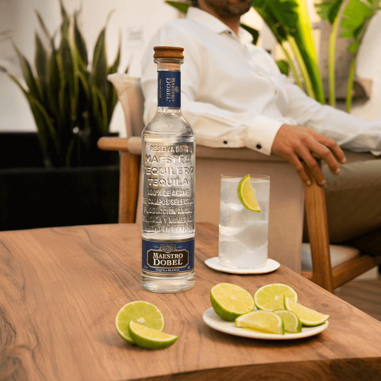 Dobel Blanco with cocktail and limes in an outdoor scene.