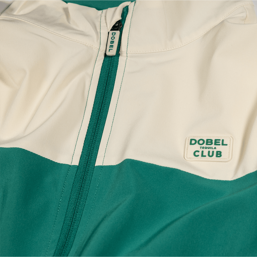 Detail shot of the front of the two-tone cream and green full zip jacket, featuring green zipper.