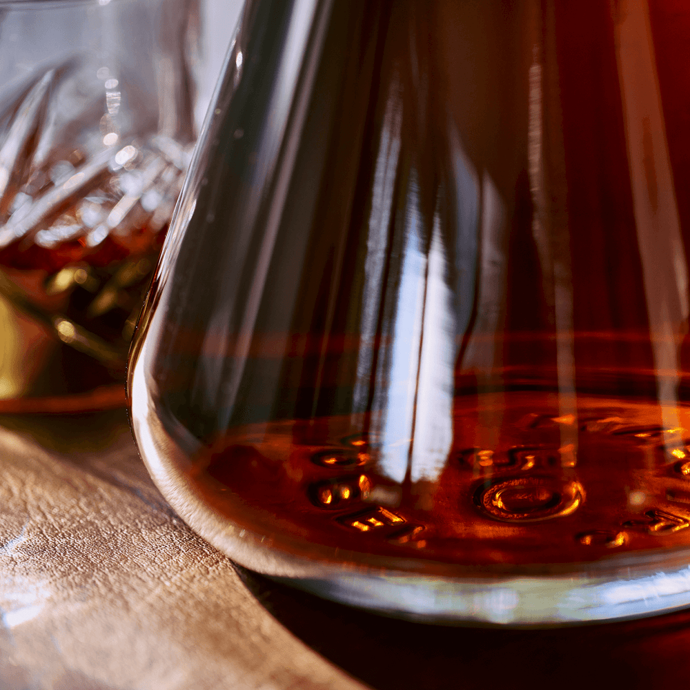 Dobel 50 Extra Añejo 1968 bottle base with glass beside.