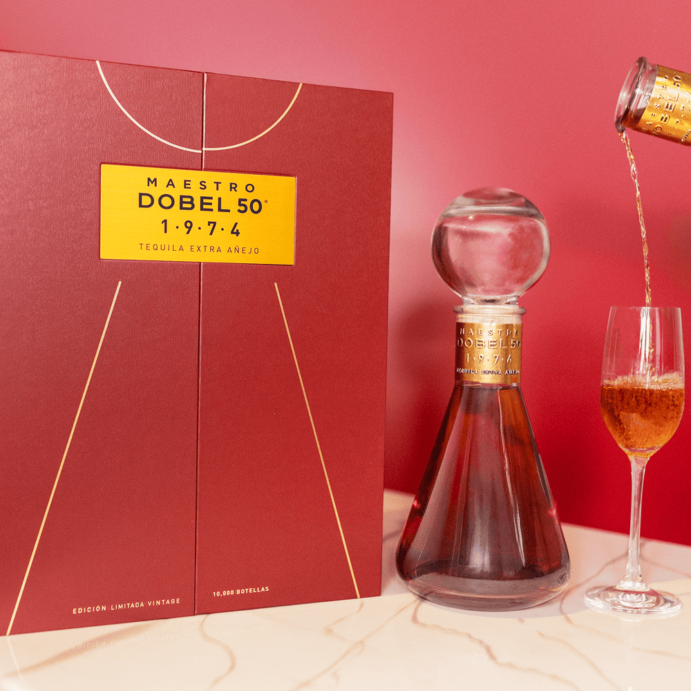 Dobel 50 Extra Añejo 1974 bottle with stemmed glass and liquid inside and box.