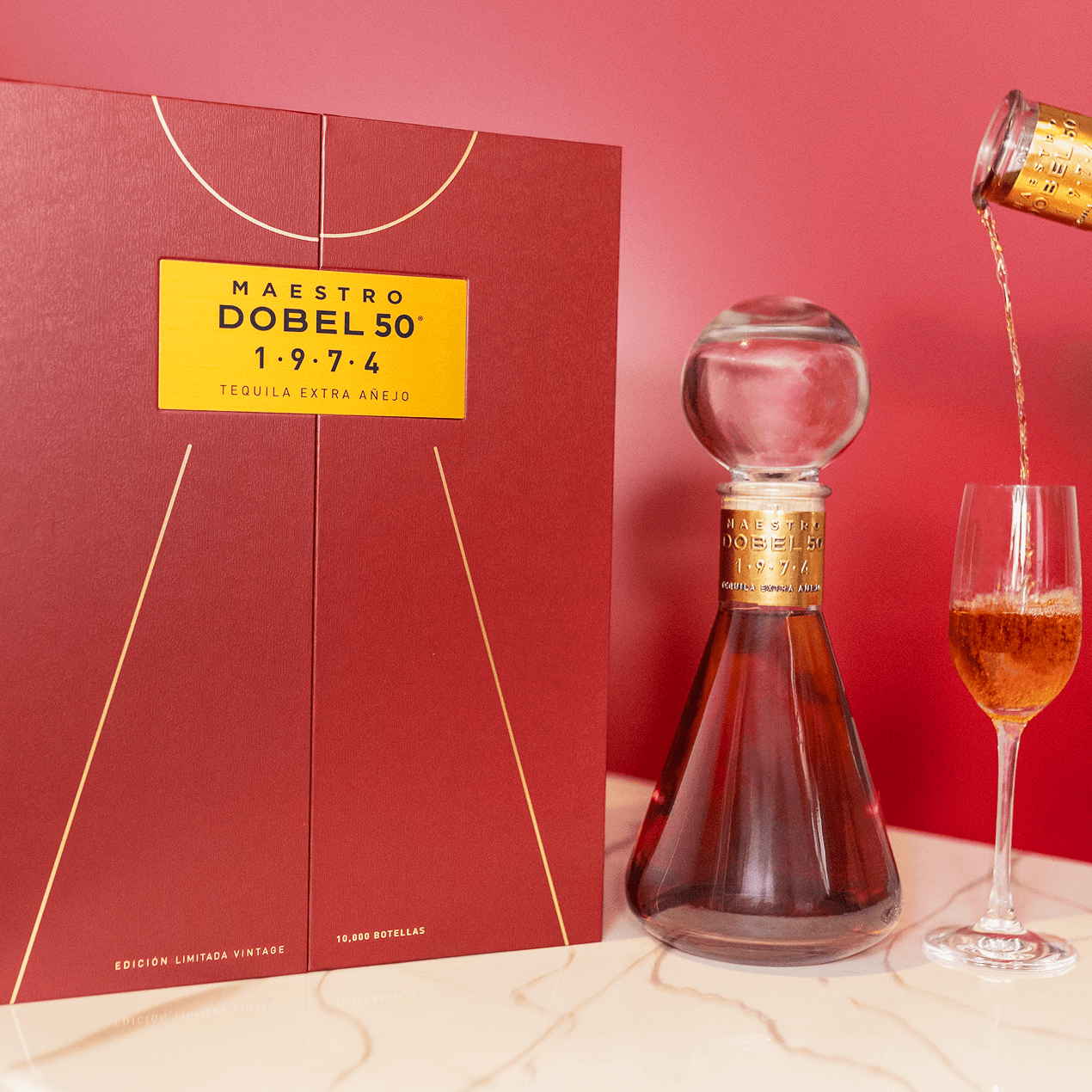 Dobel 50 Extra Añejo 1974 bottle with stemmed glass and liquid inside and box.