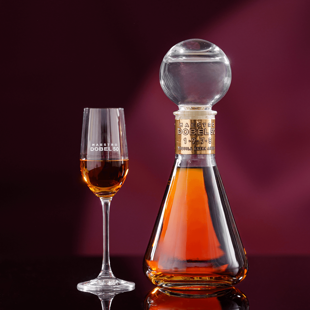 Dobel 50 Extra Añejo 1975 bottle with stemmed glass and liquid inside.