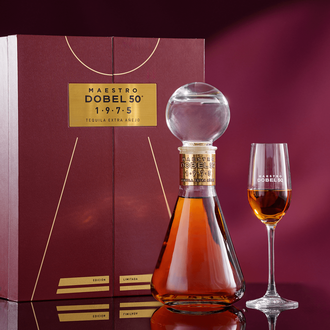 Dobel 50 Extra Añejo 1975 bottle with stemmed glass and liquid inside and box.