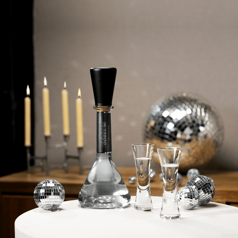 Two Dobel sipping glasses with Dobel 50 Cristalino bottle on a table for a party.