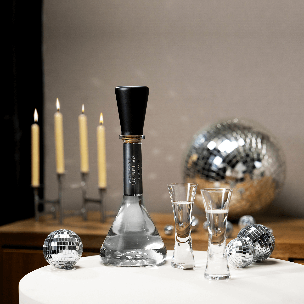 Two Dobel sipping glasses with Dobel 50 Cristalino bottle on a table for a party.